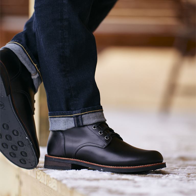 Men's casual boots standing in a dusting of snow