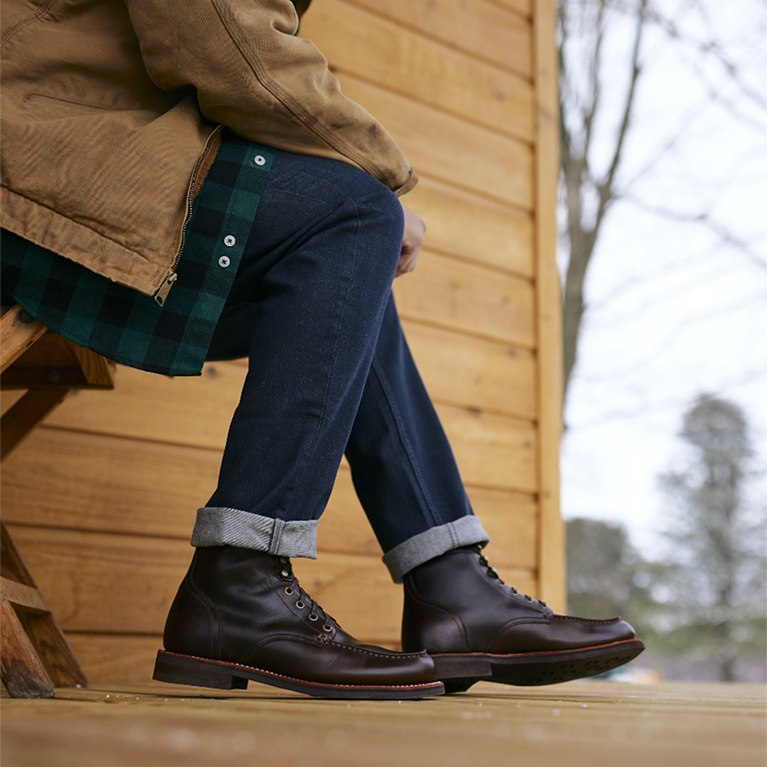 Men's leather boots on a wood deck